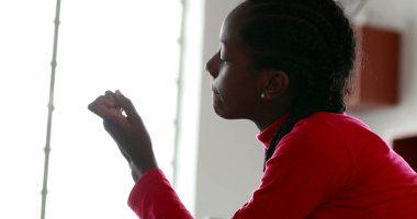 Zenci genç kız tırnaklarına bakıyor.