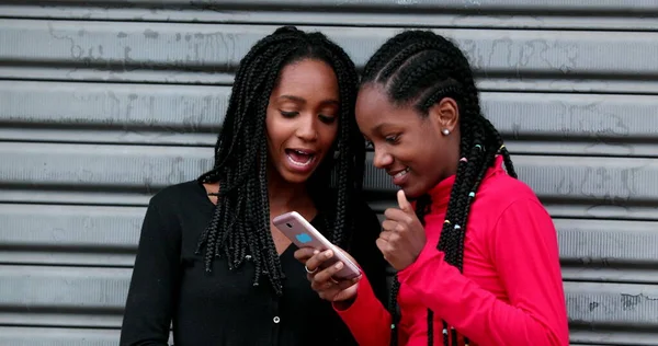 Duas Amigas Negras Rindo Usando Smartphone Juntas — Fotografia de Stock