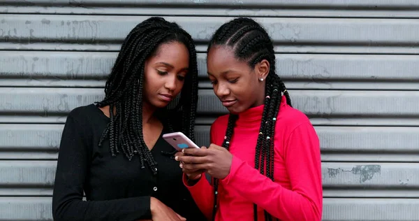 Teen Black Girls Using Cellphone Adolescent Girlfriends Laughing Smiling Social — Zdjęcie stockowe