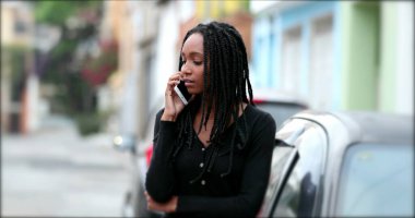 Sokak ortasında telefonla konuşan melez bir genç kız.