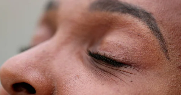 Close-up person closing eyes, black african ethnicity eye