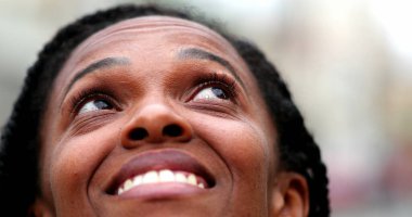 Siyah Afrikalı kadın gökyüzüne bakıp mutlu oluyor.