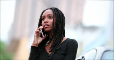 Siyah Afrikalı genç kız telefonda konuşuyor, gizli melez genç kadın cep telefonuyla konuşuyor.