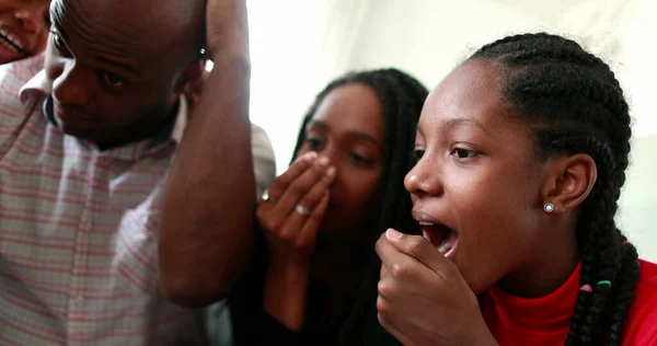 African family shock reaction looking at cellphone device. parents and children surprise reaction to smartphone news