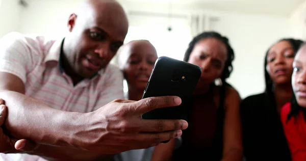 African black family checking smartphone device together