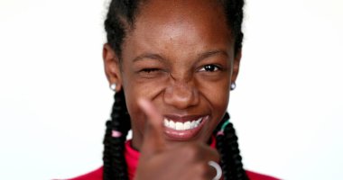 Genç kız kameraya göz kırpıyor ve başparmağını bırakıyor.