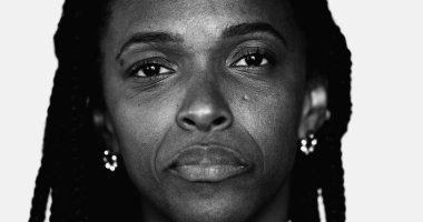 Kameraya yakından bakan ciddi bir Afrikalı siyahi kadının tek renkli portresi