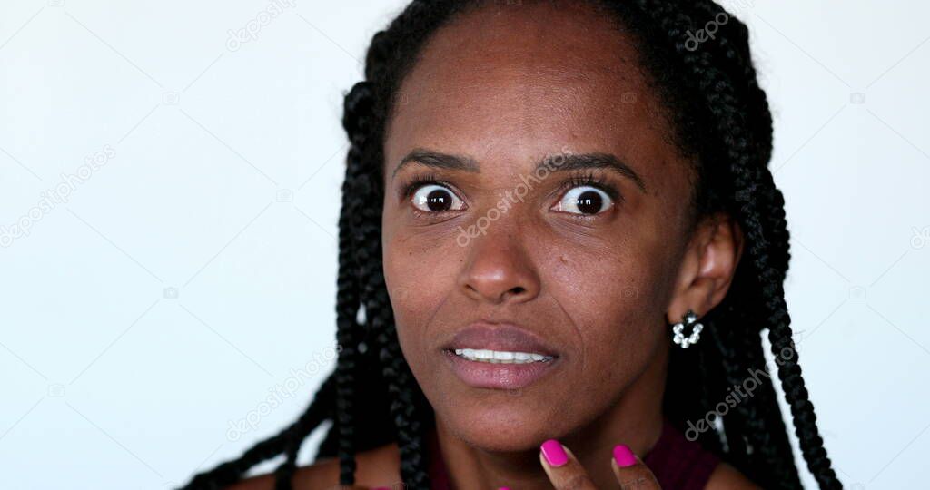 Frightened black African woman exaggerated emotional reaction to news. Anxious nervous person close-up face