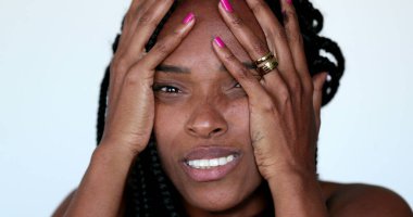 Desperate African woman screaming in HORROR to news, close-up face YELLING and desperation