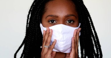 Siyah kız covid-19 yüz maskesi ayarlıyor. Maske takan Afrikalı gençler