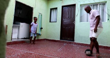 Afrikalı baba ve oğul evde futbol oynuyor, baba ve çocuk kaynaşması