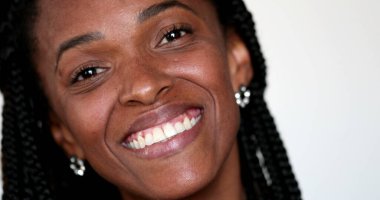 Afrikalı etnik kadın kameraya bakıp gülümsüyor.