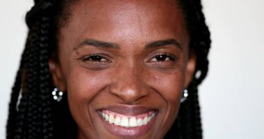 Afrikalı etnik kadın kameraya bakıp gülümsüyor.