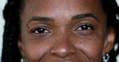 Afrikalı siyahi kadın kameraya gülümsüyor, makro yakın plan gözleri var.