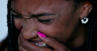 Afrikalı siyahi kadın çaresizlik içinde ağlıyor. Depresif ruh hali, duygusal üzüntü ve kahkaha.