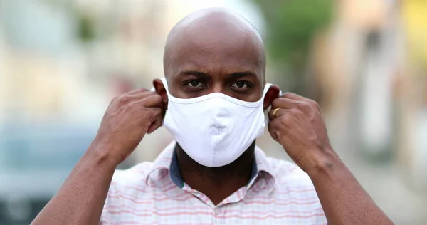 African man removing face mask feeling relief, black guy takes off covid-19 face mask