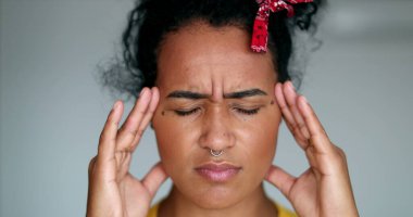 Stres ve baskı hisseden endişeli genç bir kadın. Siyah kız kafaya dokunuyor.