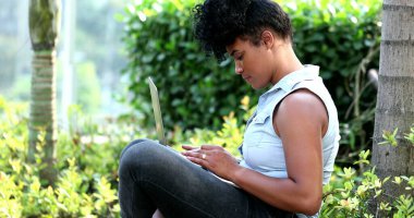 Dışarıda dizüstü bilgisayar kullanan Afrikalı kadın