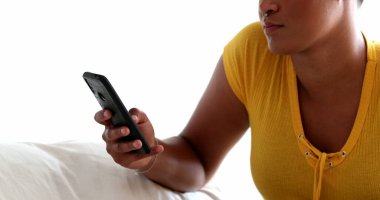 Evde cep telefonu tutan Afrikalı kadın elleri.