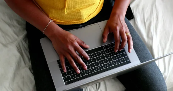 Black woman hands typing on laptop computer