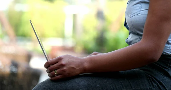 Black woman hands opening laptop computer outside