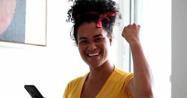 Mutlu gülümseyen melez kadın mesaj okuma başarısını kutluyor