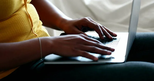 Black woman typing on laptop
