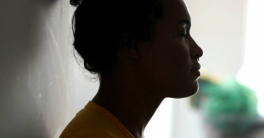 Ruhani siyah kadın ellerini göğsüne koyup meditasyonda duvara yaslanıyor.