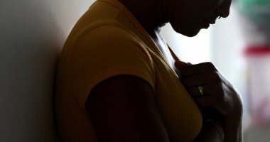 Ruhani siyah kadın ellerini göğsüne koyup meditasyonda duvara yaslanıyor.