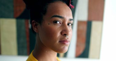 Kameraya bakan kendinden emin genç siyahi kadın. Karışık ırk kızı yüzü