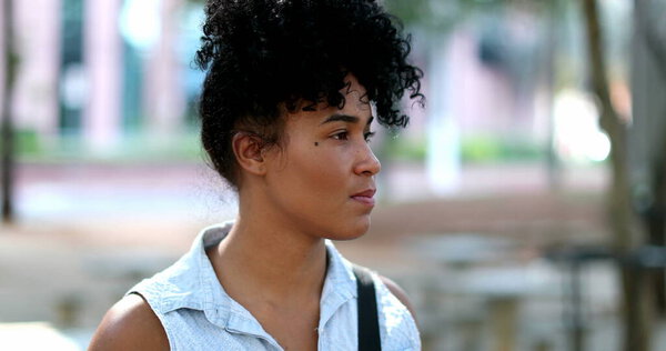 Pensive young mixed race woman standing outside