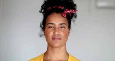 Yüzünde ciddi bir ifade olan genç zenci kadın.