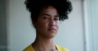 Genç siyah kadın kameraya bakıp gülümsüyor.