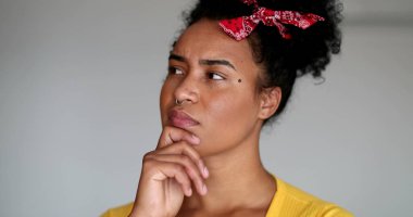 Bir soruna çözüm arayan genç siyahi kadın kameraya bakar.