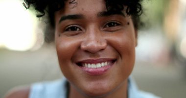 Genç siyahi kadın fotoğraf çekimine gülümsüyor.