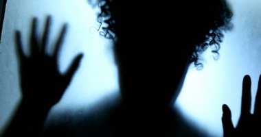 Kadın cam pencerenin arkasında kapana kısılmış hissediyor, depresyon mücadele kavramı