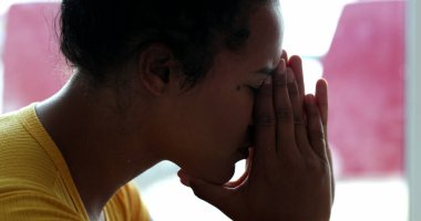 Stresli bir insan, elleri yüzü üzerinde. Endişeli genç siyah kadın