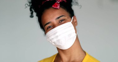 Mixed race young black woman putting mask against virus
