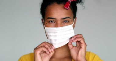 Mixed race young black woman putting mask against virus
