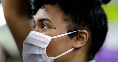 Metro tırabzanı tutan banliyö banliyösü, Coperid 19 yüz maskesi takıyor. Toplu taşımacılıkta siyahi kız yüzü