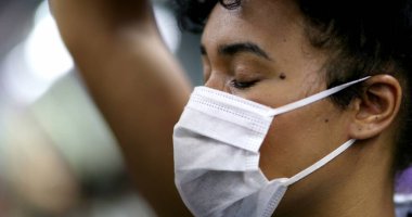 Metro tırabzanı tutan banliyö banliyösü, Coperid 19 yüz maskesi takıyor. Toplu taşımacılıkta siyahi kız yüzü