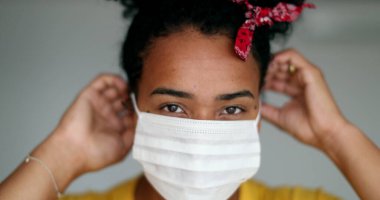 African american woman putting covid-19 face mask prevention against disease