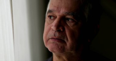 Düşünceli yaşlı bir adam pencerenin kenarında durup düşünüyor. Düşünceli üzgün bunalımlı son sınıf öğrencisi.