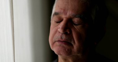 Düşünceli yaşlı bir adam pencerenin kenarında durup düşünüyor. Düşünceli üzgün bunalımlı son sınıf öğrencisi.