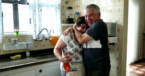 Karı koca başarıyı kutluyor. Yaşlı evli çift sarılıp öpüşüyor.