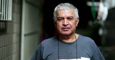 Ciddi bir yaşlı adam kameraya bakıyor. Sıradan bir son sınıf resmi, ciddi bir ifade.