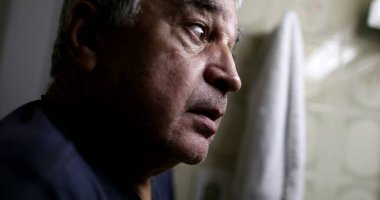 Yaşlı bunalımlı ihtiyar, banyo aynasının önünde.