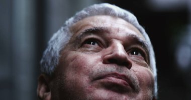 Yaşlı adam gökyüzüne umutla ve inançla bakıyor.