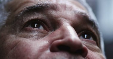 Yaşlı adam gökyüzüne umutla ve inançla bakıyor.