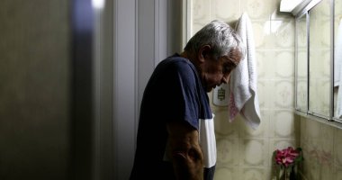 Yaşlı adam elinde haç işareti ile af diliyor.